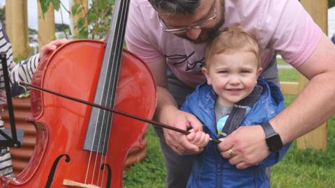 Dylan o Lan Conwy, yn cael gwersi sielo gan ei dad Simon yn yr Arddorfa