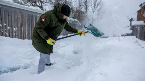 Iowa resident clears snow from his driveway.