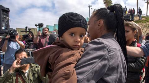 Woman holding child at San Ysidro