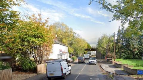 A street view image showing Hare Lane and the railway bridge