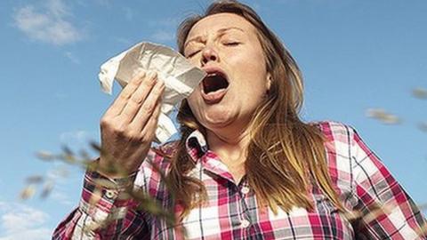 Woman sneezing in a field