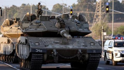 Israeli tanks seen on a road near Israel's border with the Gaza Strip, in southern Israel, 20 October