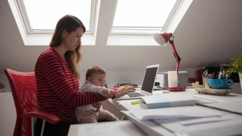 Woman working from home with baby.
