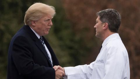 US President Donald Trump shakes hands with White House Physician Rear Admiral Dr Ronny Jackson, following his annual physical in Maryland, January 2018