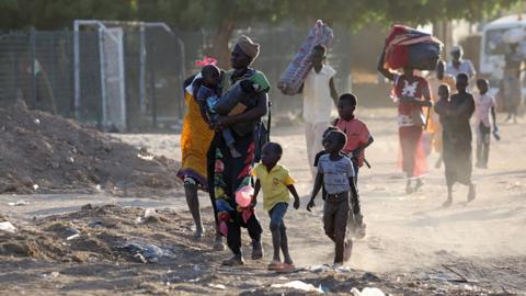 People flee their neighbourhoods amid fighting between the army and paramilitaries in Khartoum