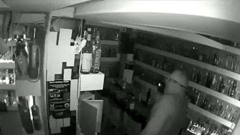 CCTV image shows thief examining bottles of vodka