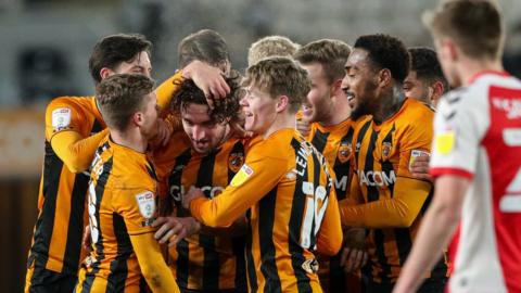 Hull City players mob match-winner Lewie Coyle