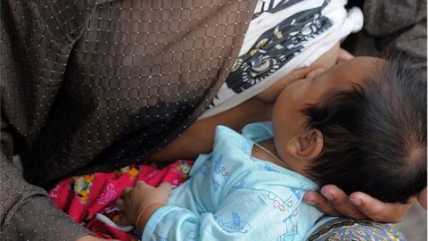 A woman feeds a baby at a village on the outskirts of Siem Reap province, some 300 kilometers northwest of Phnom Penh on 22 February 2011.