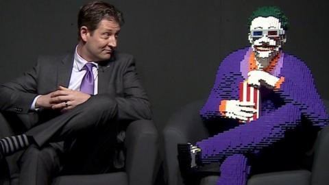 Nathan Sawaya sits with a Lego version of The Joker