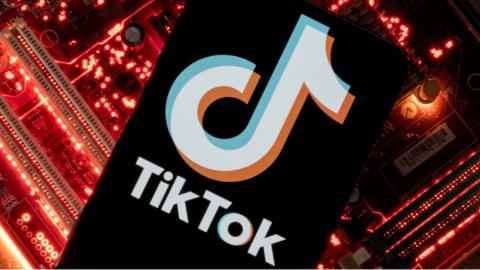 A smartphone with a displayed TikTok logo on a computer motherboard.