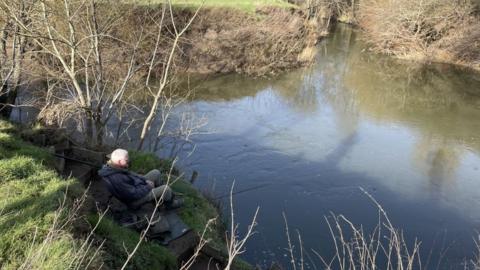 A man fishing in the River Medway