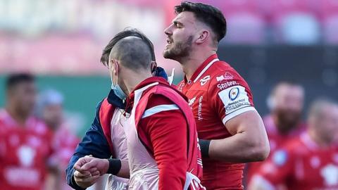 Johnny Williams is helped off the field against Sale Sharks