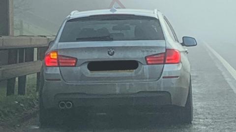 Car stopped by police in fog
