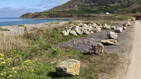 The boulders before they were removed from the verge