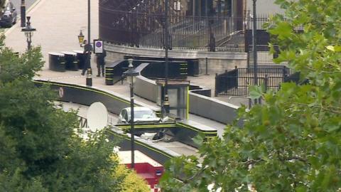 Still frame from 鶹ҳ News footage of the car which crashed into security barriers outside the Houses of Parliament.