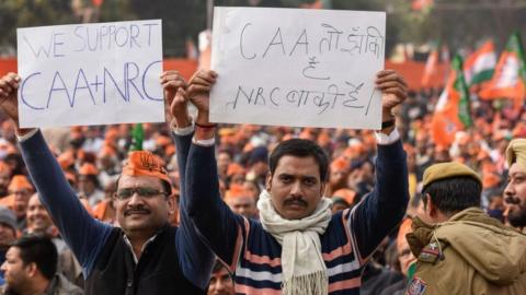 Bharatiya Janta Party (BJP) supporters hold placards in support of the Citizenship Amendment Act (CAA) and National Register of Citizens (NRC) during a rally addressed by Prime Minister Narendra Modi along with other party leaders, at Ramlila Ground on December 22, 2019 in New Delhi, India.