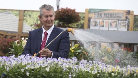 Edwin Poots watering flowers at a garden centre