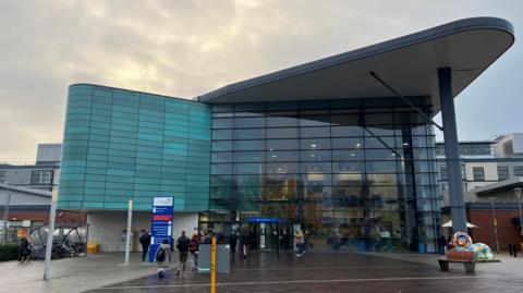Exterior of hopsital building, rectangular building with large glass windows and dome shaped roof