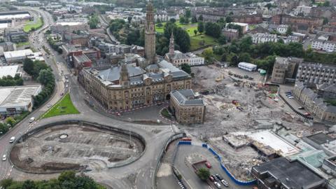 A Victorian town hall surrounded by empty spaces where buildings have been demolished