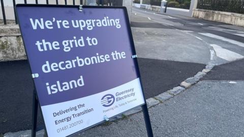 A road sign which says: We're upgrading the grid to decarbonise the island