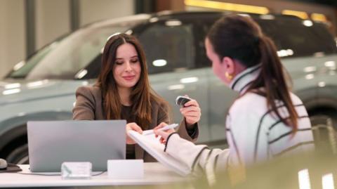 A car dealer agreeing a sale with a customer