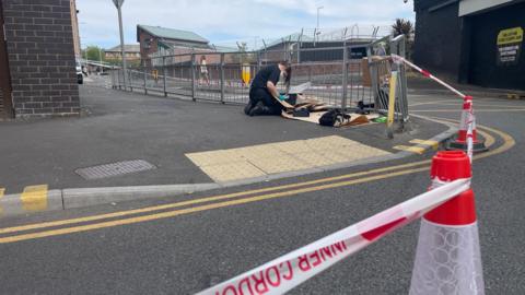 A police worker behind a cordon. The tape reads "inner cordon"