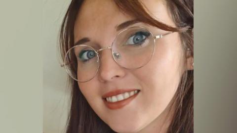 Lucy Greenstreet is wearing glasses and smiling at the camera.