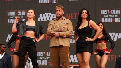Ronda Rousey and Gina Carano pose for pictueres with Jake Paul in the middle