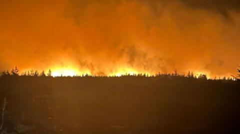 The moorland fire across North York Moors National Park at night.