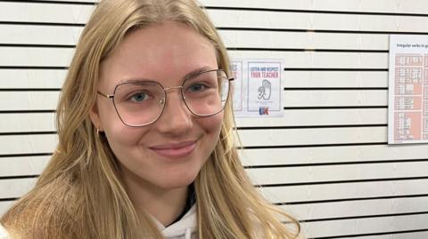 A head and shoulders picture of Vlada Zabielina, a Ukrainian refugee now living in Southend. She has long blonde hair and is wearing glasses.