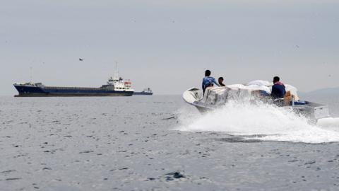 Vessels and a boat at the Strait of Hormuz, off the coast of Oman’s Musandam province