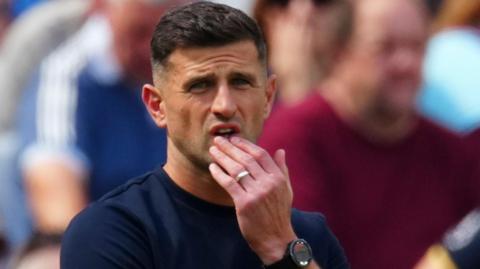Portsmouth boss John Mousinho looks on from the sidelines and he was surprised by his side's capitulation against QPR.