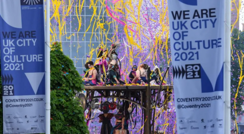Performers dance and sing on a stage in Coventry, to mark the city's year as UK City of Culture in 2021
