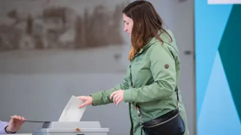 A voter casts her ballot at a polling station in the snap federal parliamentary elections on February 23, 2025 in Arnsberg, Germany. Germany is holding elections today following the collapse of the three-party government coalition last November.