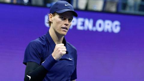 Jannik Sinner holds up his fist to celebrate
