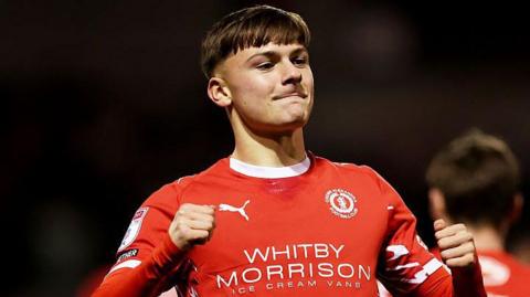 Emre Tezgel gives a double tumbs-up to the crowd after scoring for Crewe