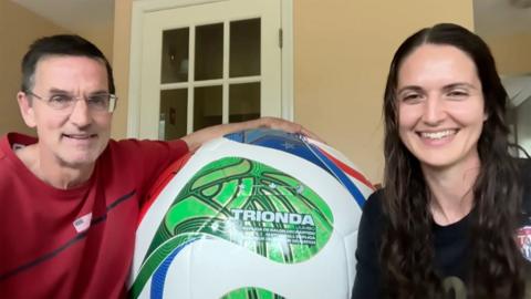 A man and woman with a giant world cup ball