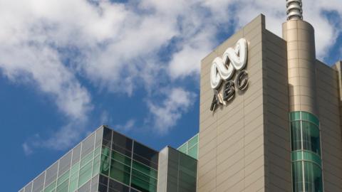 ABC Australia's building and logo against a blue sky background with some white clouds