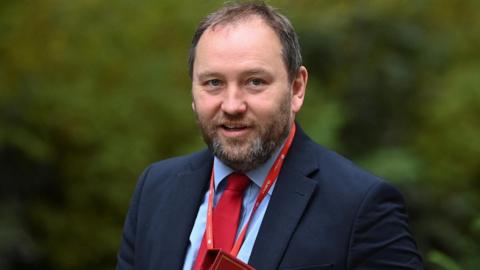 Ian Murray walking down downing street carrying a red folder