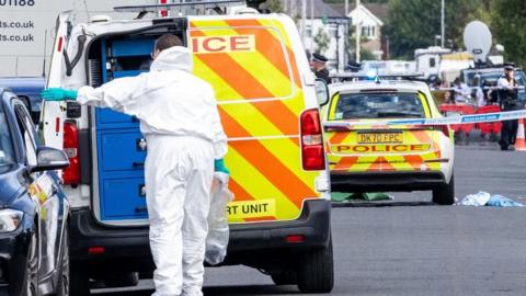 A police scenes-of-crime officer (SOCO) at the scene in Southport, Merseysid