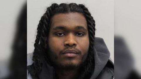 Awad Abdel Samad is seen close up in a police mugshot. He is seen wearing a grey hoodie.