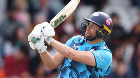 Dawid Malan swings his bat and looks to the sky while batting for Yorkshire last season