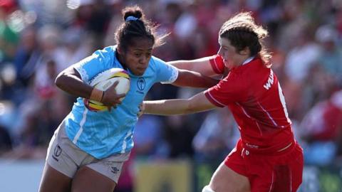 Fiji's Manuqalo Komaitai handing off Wales' Kate Williams while running with the ball