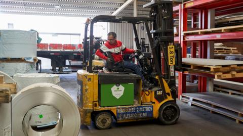  A worker uses a forklift to move steel and aluminum materials at an auto parts manufacturer in Mexico