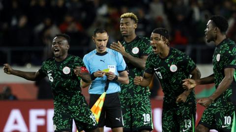 Nigeria players celebrate winning a penalty shootout against Egypt