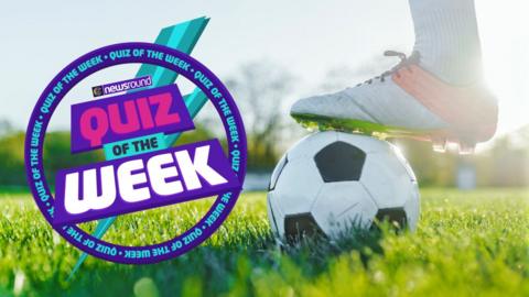 a foot on top of a football on the grass 