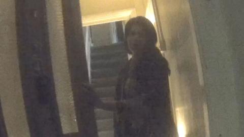 Woman opening a front door to a house