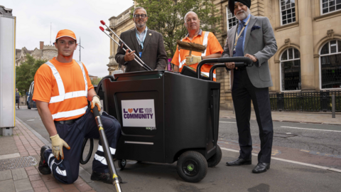 Kian Gore, street cleaner, Shaun Boyce, projects and social media manager at BID, Ken Skillern, street cleaner and councillor Bhupinder Gakhal, cabinet member for resident services stand in a city street. They hold the equipment between them