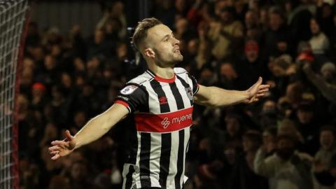 Charles Vernam of Grimsby Town scores a goal and celebrates