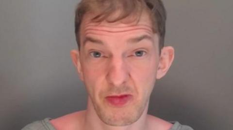Mugshot of Bates. He has a large chin and lips and short fair hair.